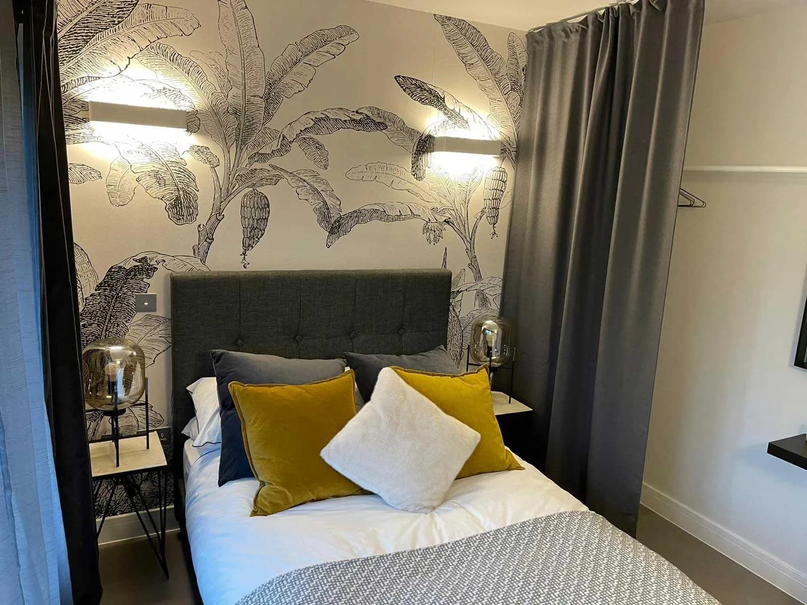 Bedroom finished with botanical wallpaper and fitted storage